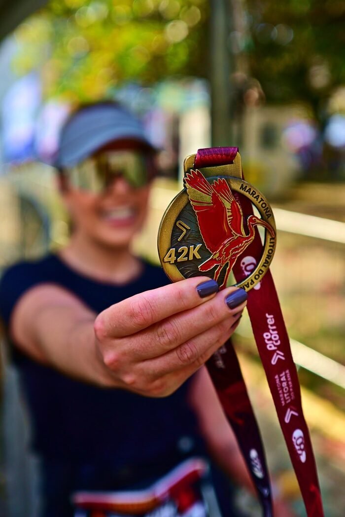 Karla Pluchiennik Moreira exibindo a medalha de 42km da Maratona Litoral do Paraná